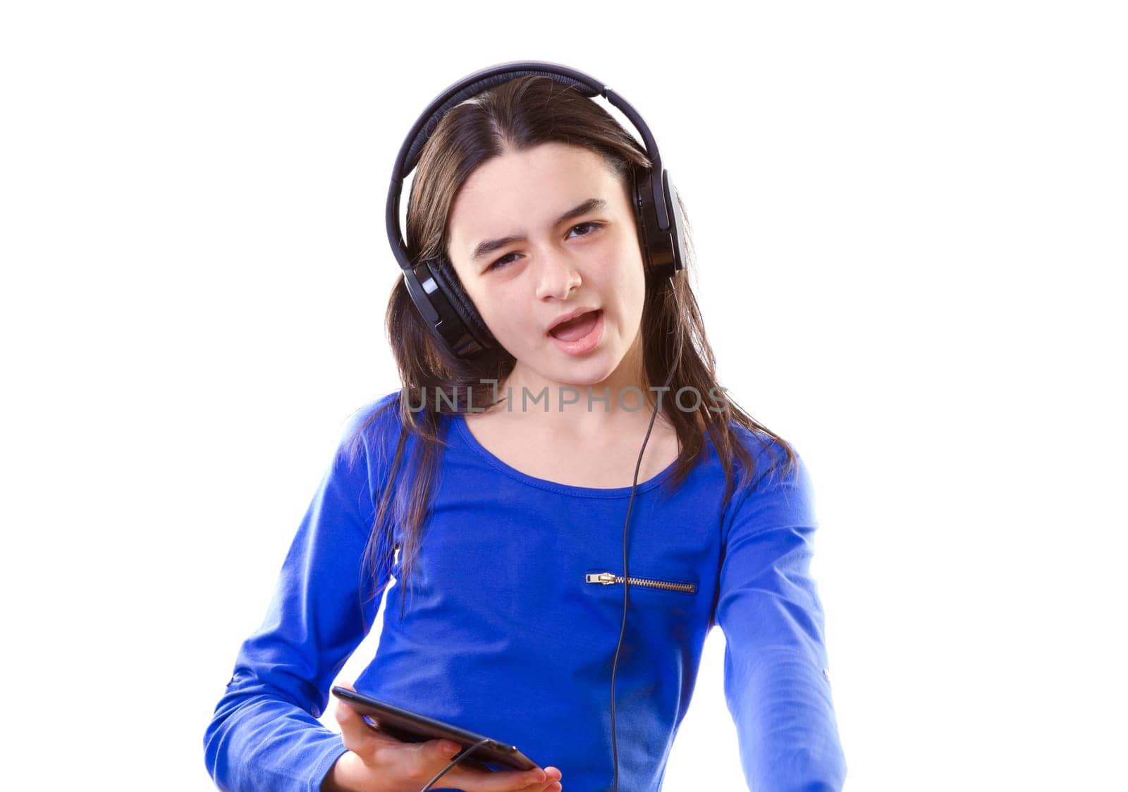 Smiling girl listening to music, holding a tablet pc in hands
