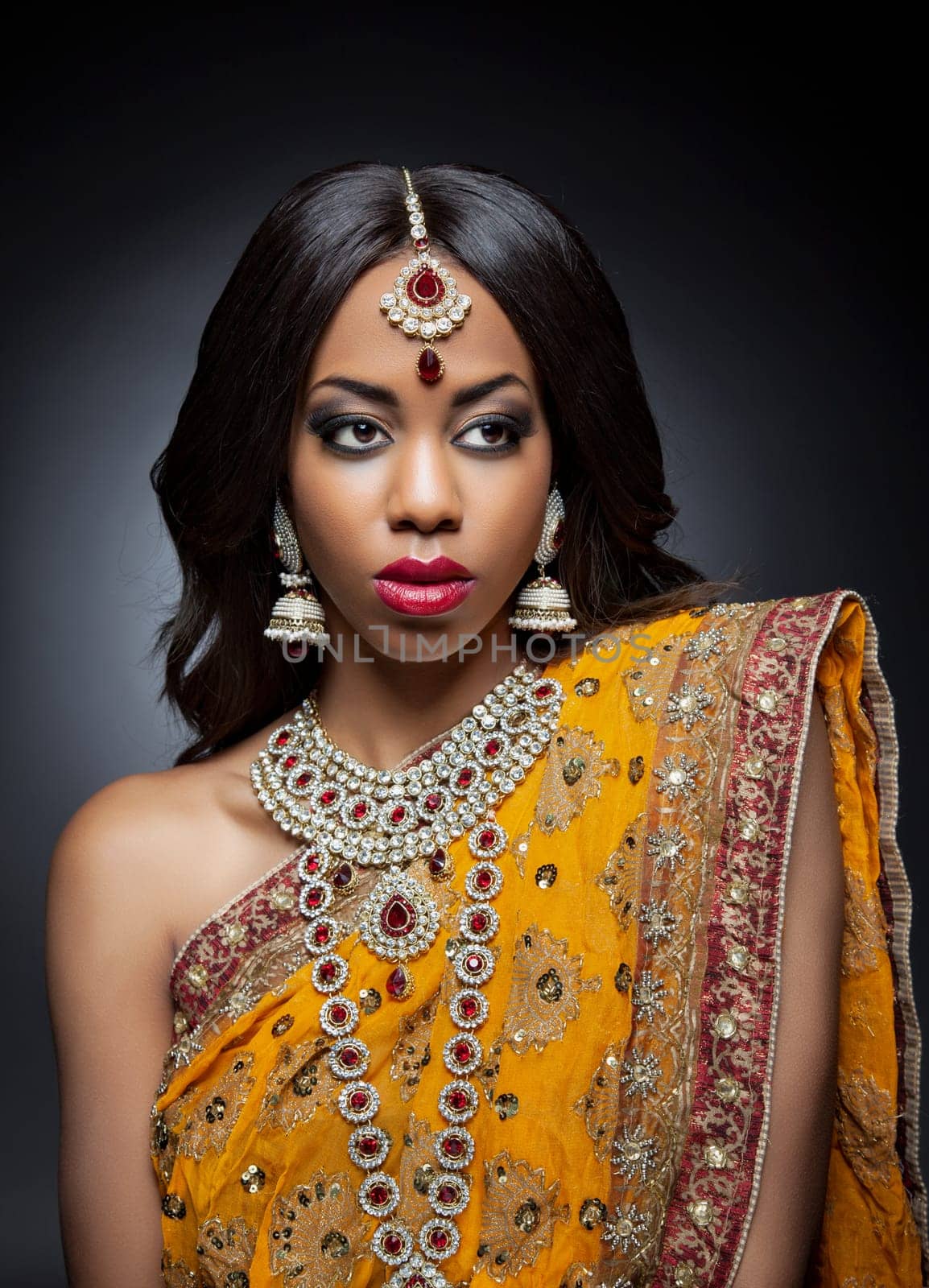 Young Indian woman dressed in traditional clothing with bridal makeup and jewelry