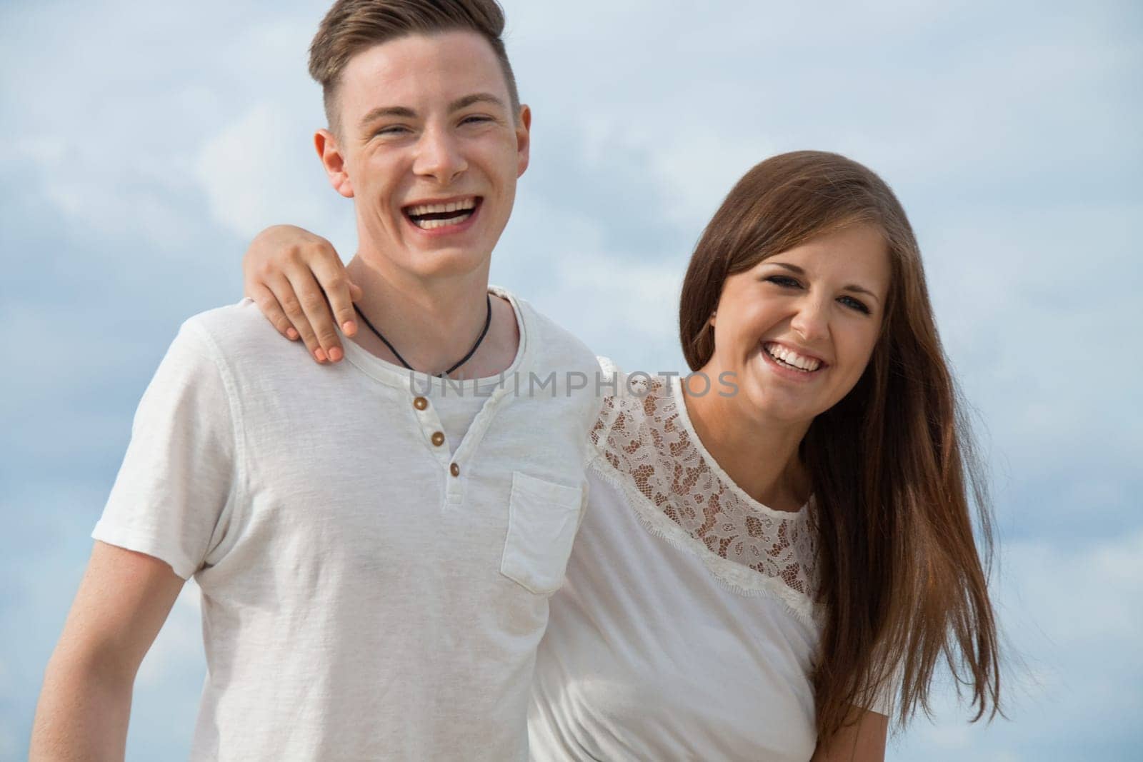 Laughing young couple in love on the beach in summer holiday leisure happy love