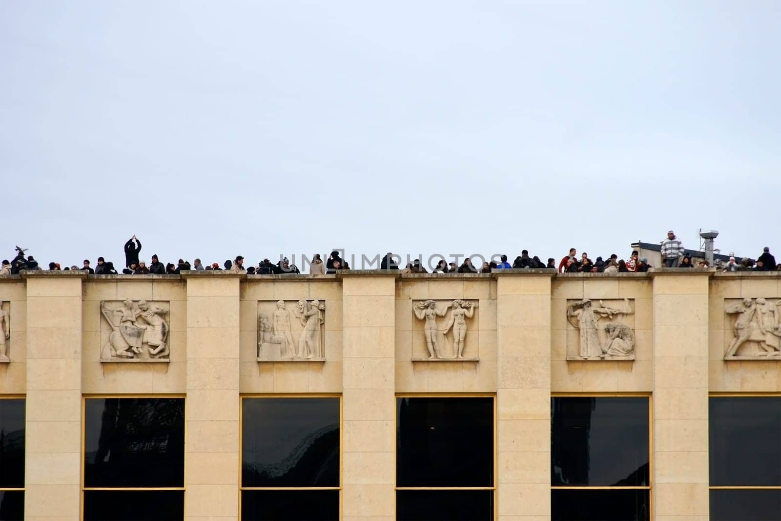 Paris,France – December 29,2013: Tourists stand on a platform on the Champ de Mars and photograph the Eiffel Tower in Paris on December 29,2013.