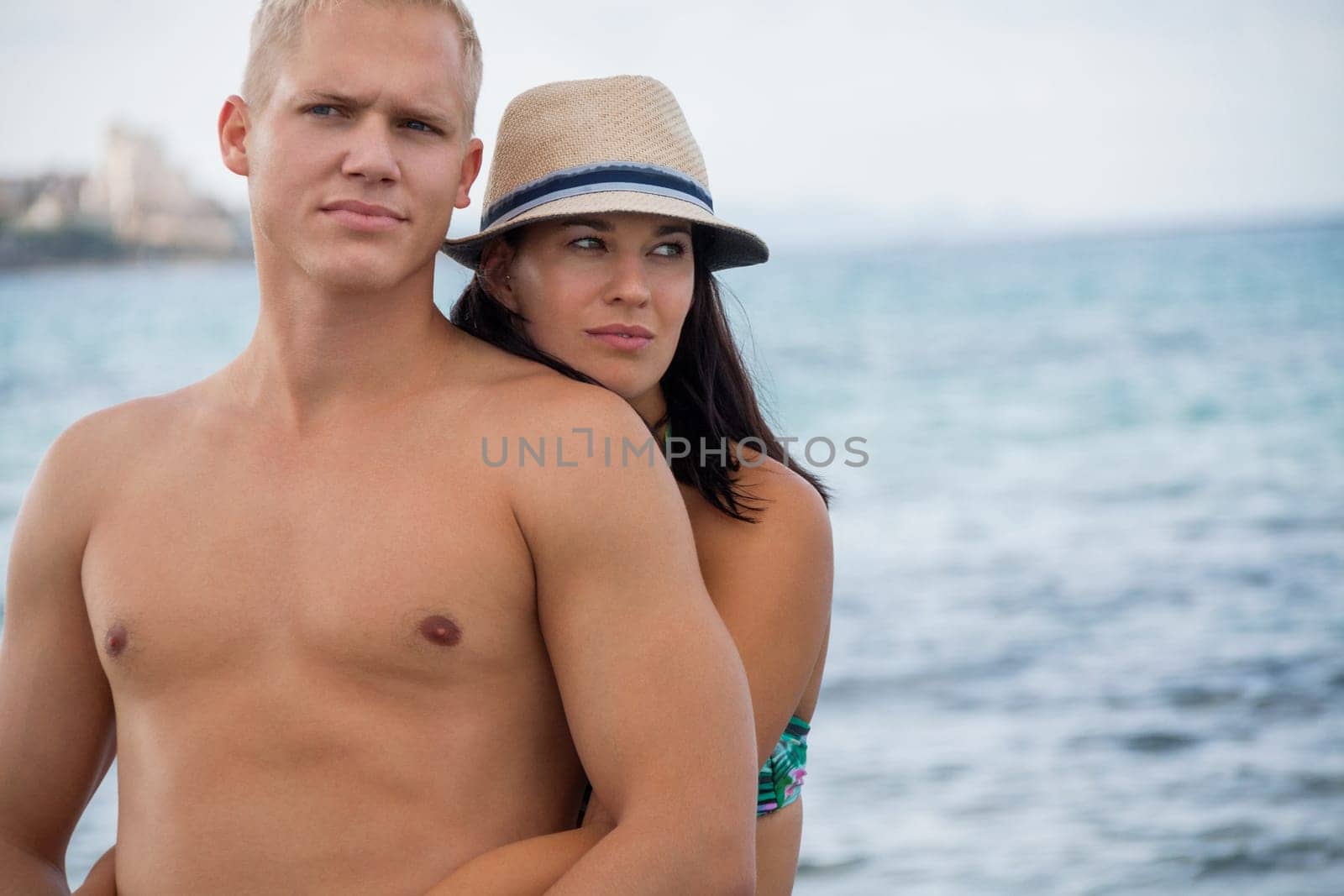 Laughing young couple in love on the beach in summer holiday leisure happy love