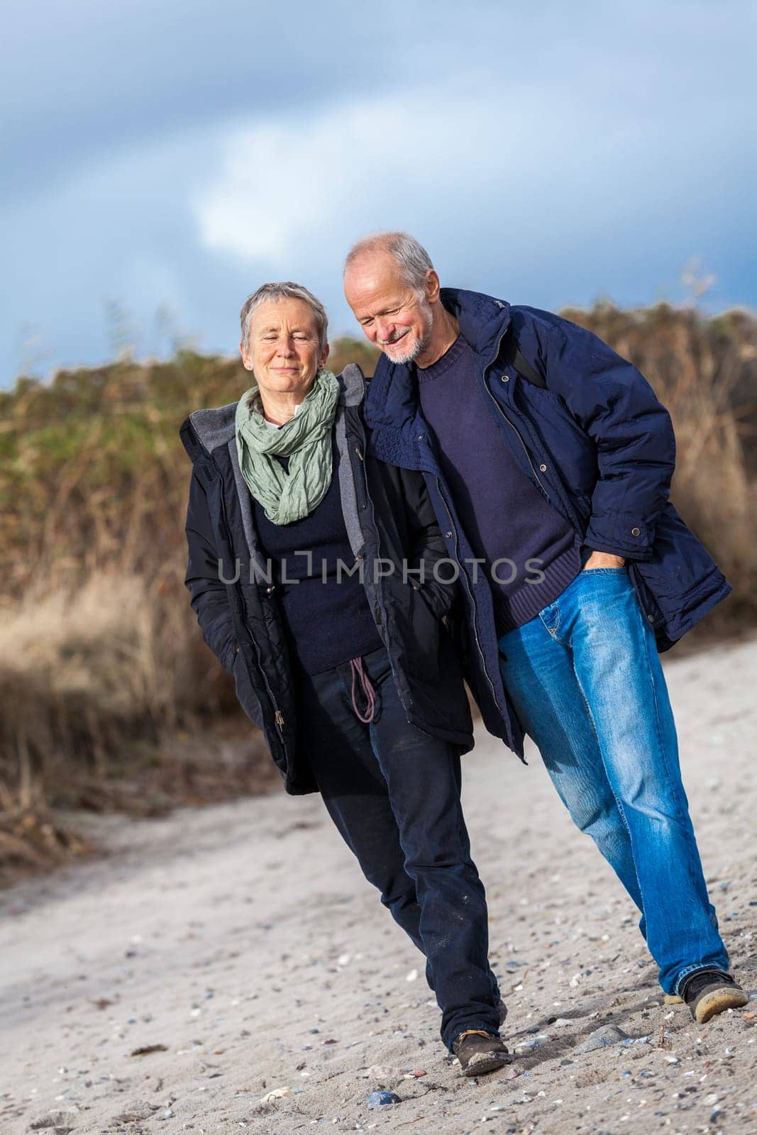 Older adult senior couple walking on the beach lifestyle happy healthy