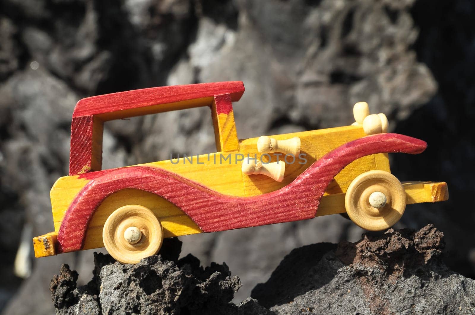 Transportation Concept Wooden Toy Car on the Rocks