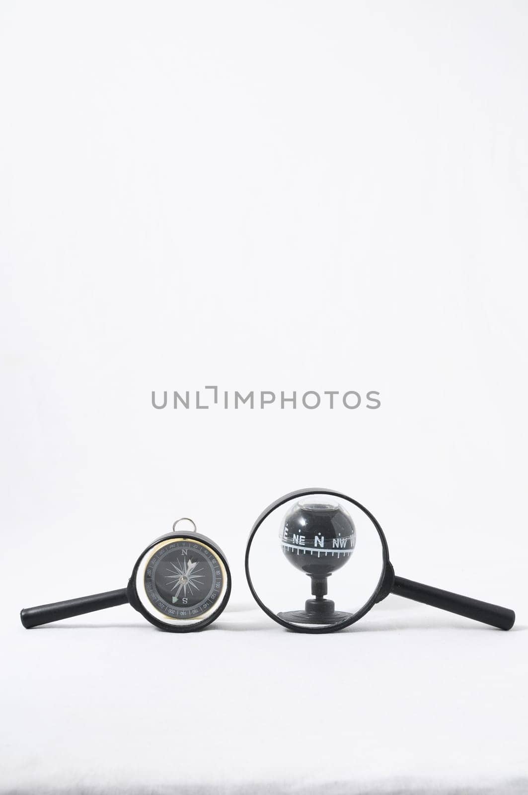 Orientation Concept Magnify Glass and Compass on a White Background