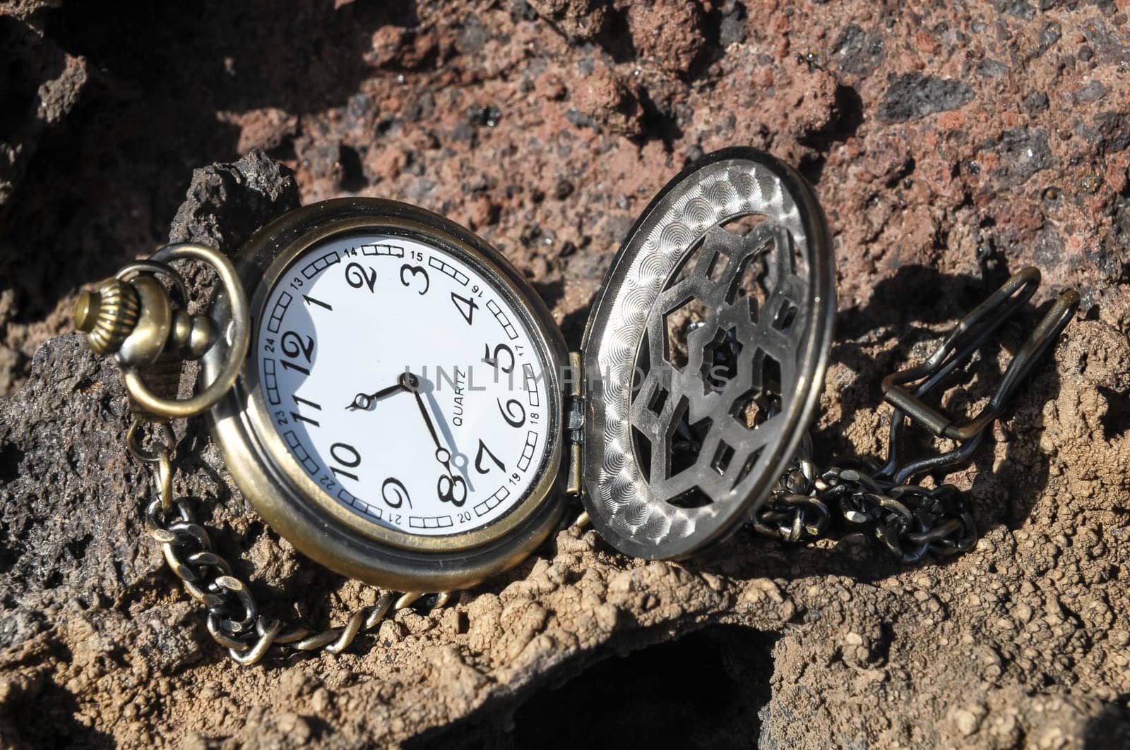 Time Concept Classic Vintage Pocket Clock on the Volcanic Rocks