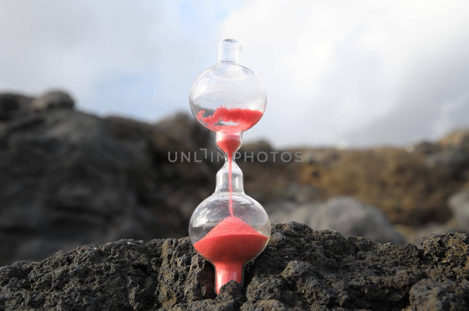 Time Concept - Hourglass Abandoned on the Volcanic Rocks