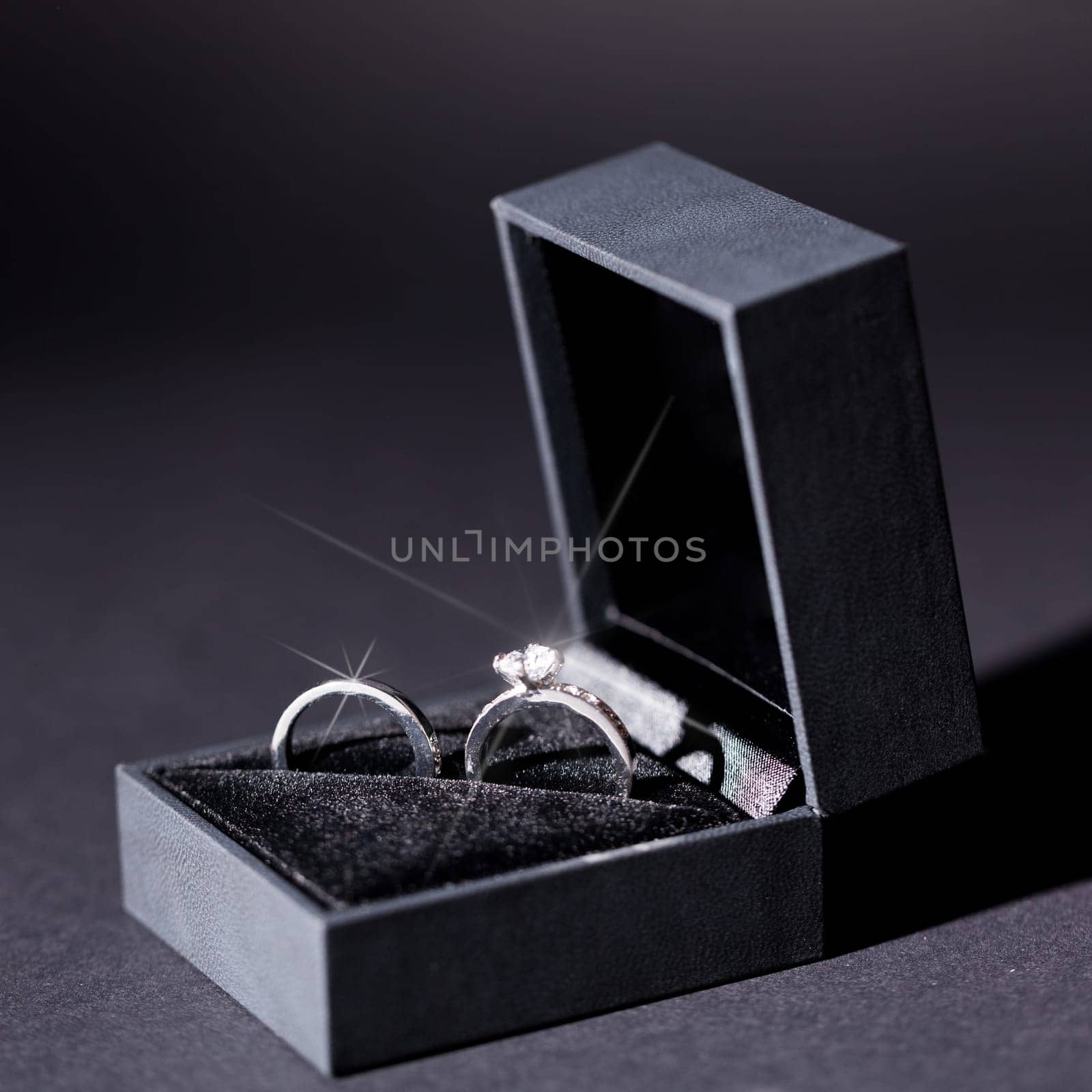 Engagement ring in a black box and a red rose macro detail Valentine's Day