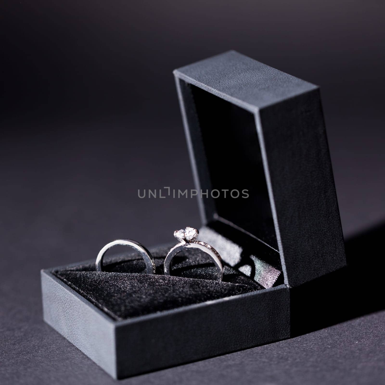 Engagement ring in a black box and a red rose macro detail Valentine's Day