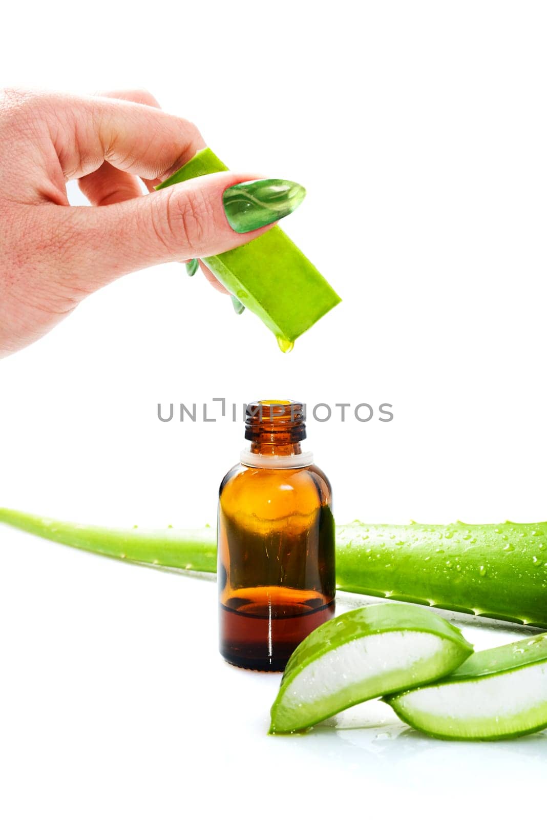 Woman's hand dropping a drop from a leaf of aloe vera in a bottle