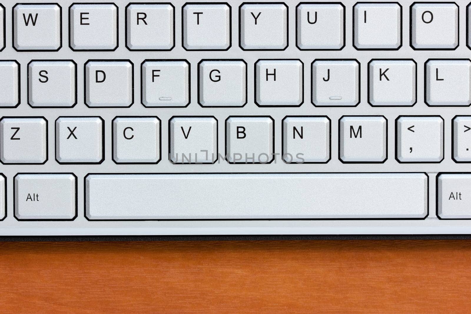 Silver computer keyboard on the wooden desk