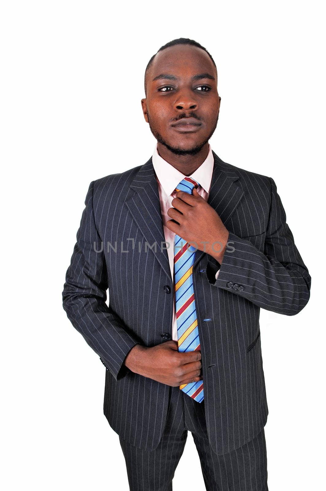 A young black business man standing in a suit and tie, fixing his tie.for white background..