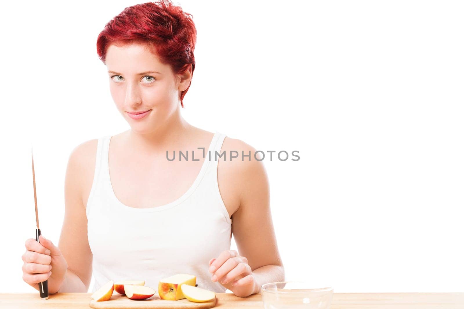 Cheeky young woman with knife has cut an apple against a white background