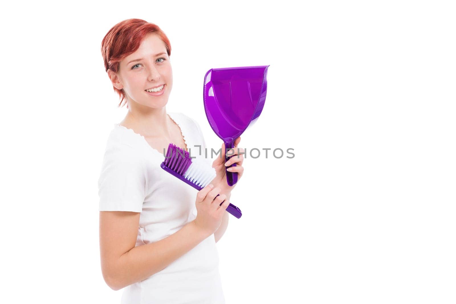 Happy young woman with broom and shovel against a white background