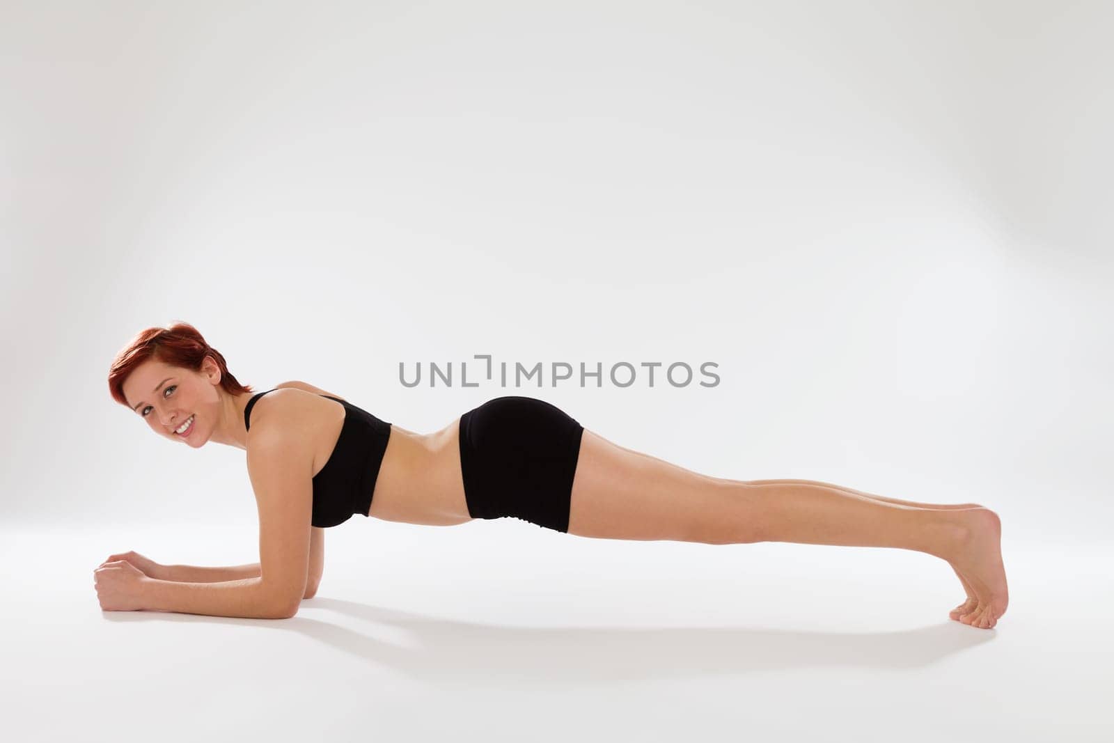 Young woman at fitness exercises elbow push-ups