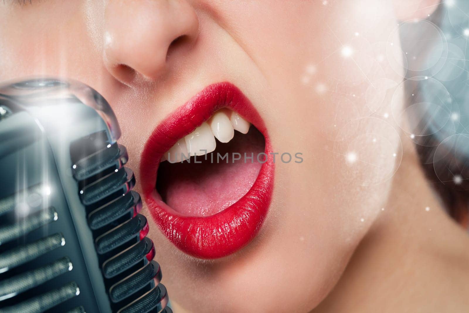Mouth of a beautiful woman with red lipstick singing into a microphone