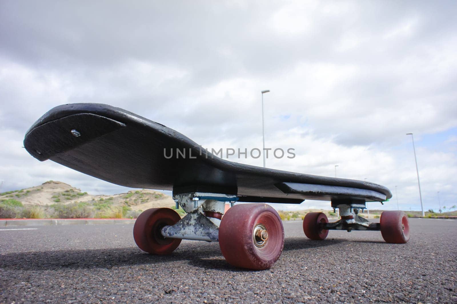 Vintage Style Longboard Black Skateboard on an Empty Asphalt Desert Road