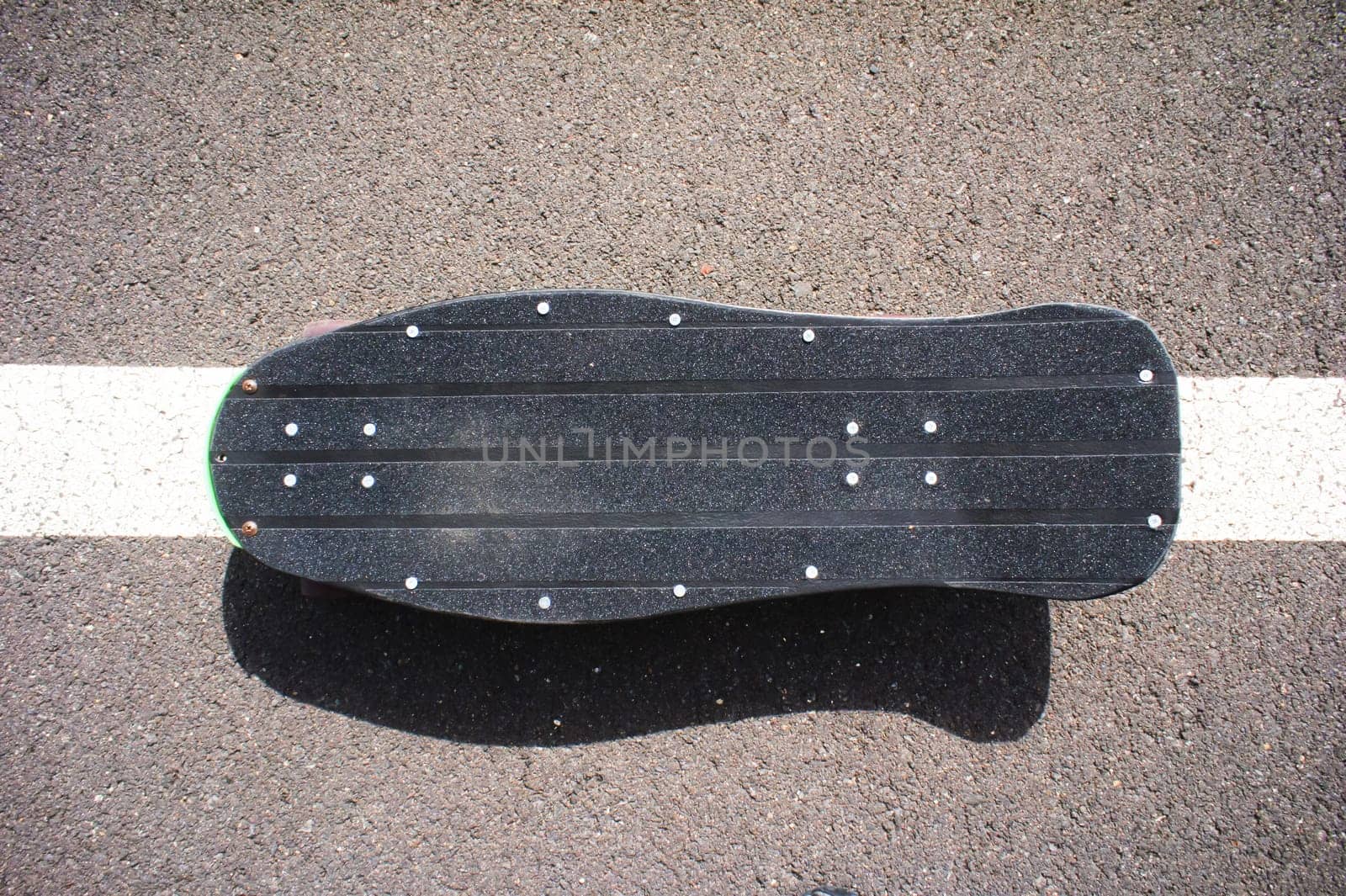 Vintage Style Longboard Black Skateboard on an Empty Asphalt Desert Road