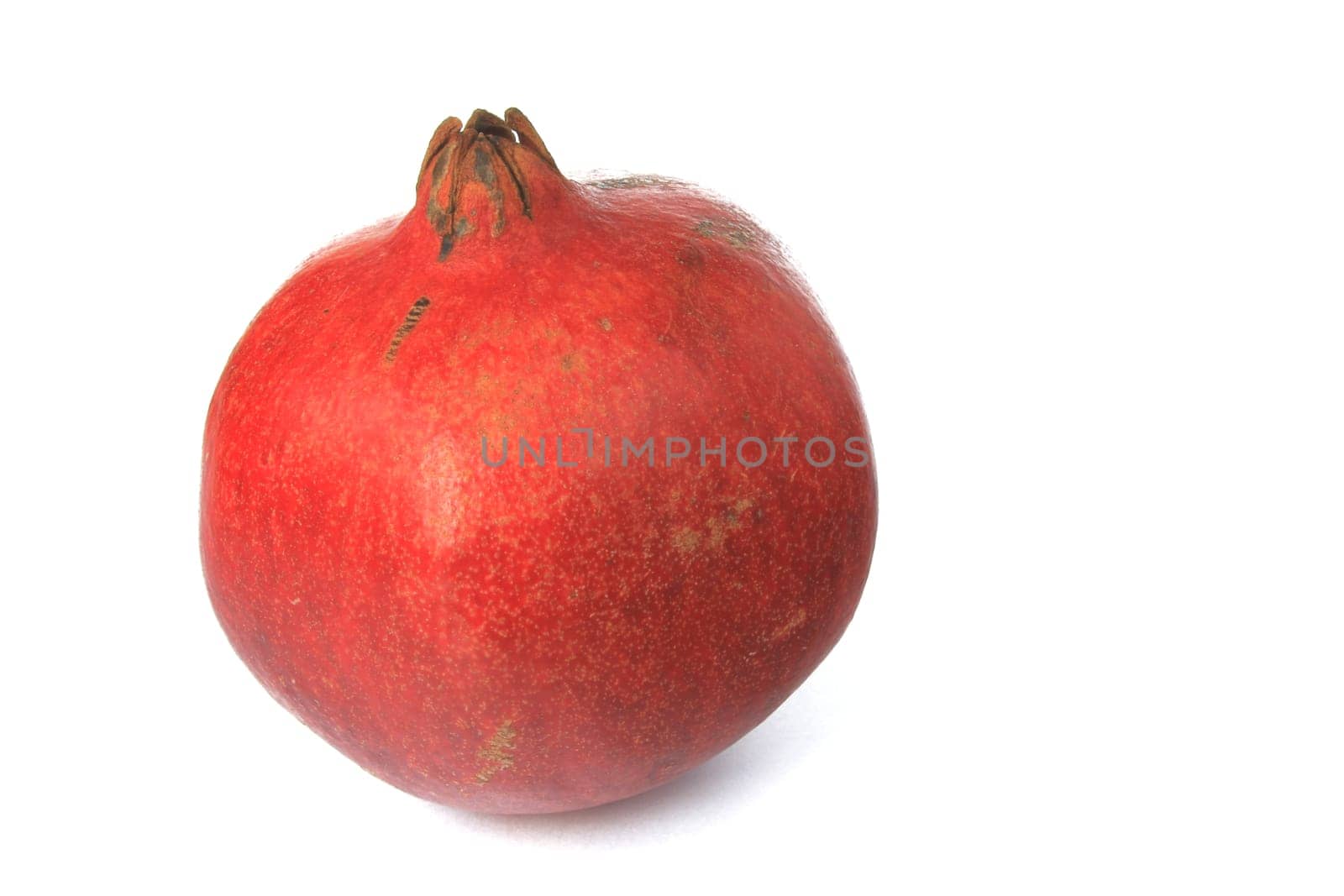 Ripe pomegranate (Punica granatum) exposed against a white background