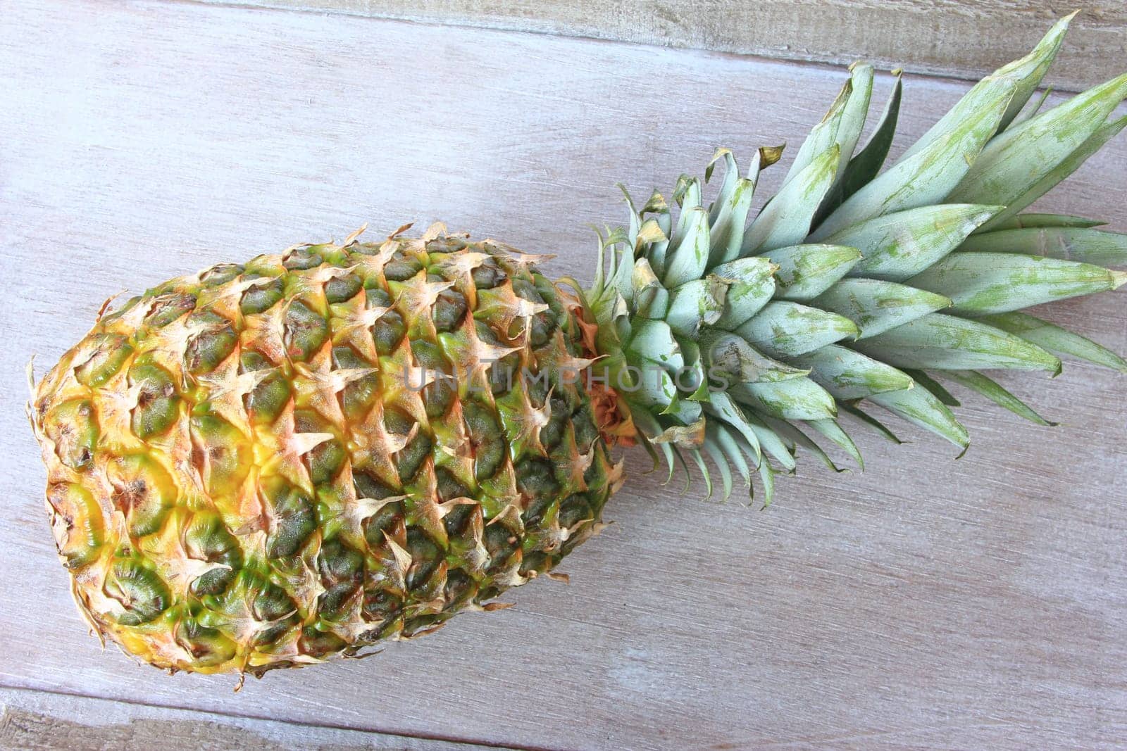 Pineapple (Ananas comosus,Ananas sativus) on an old wooden tray