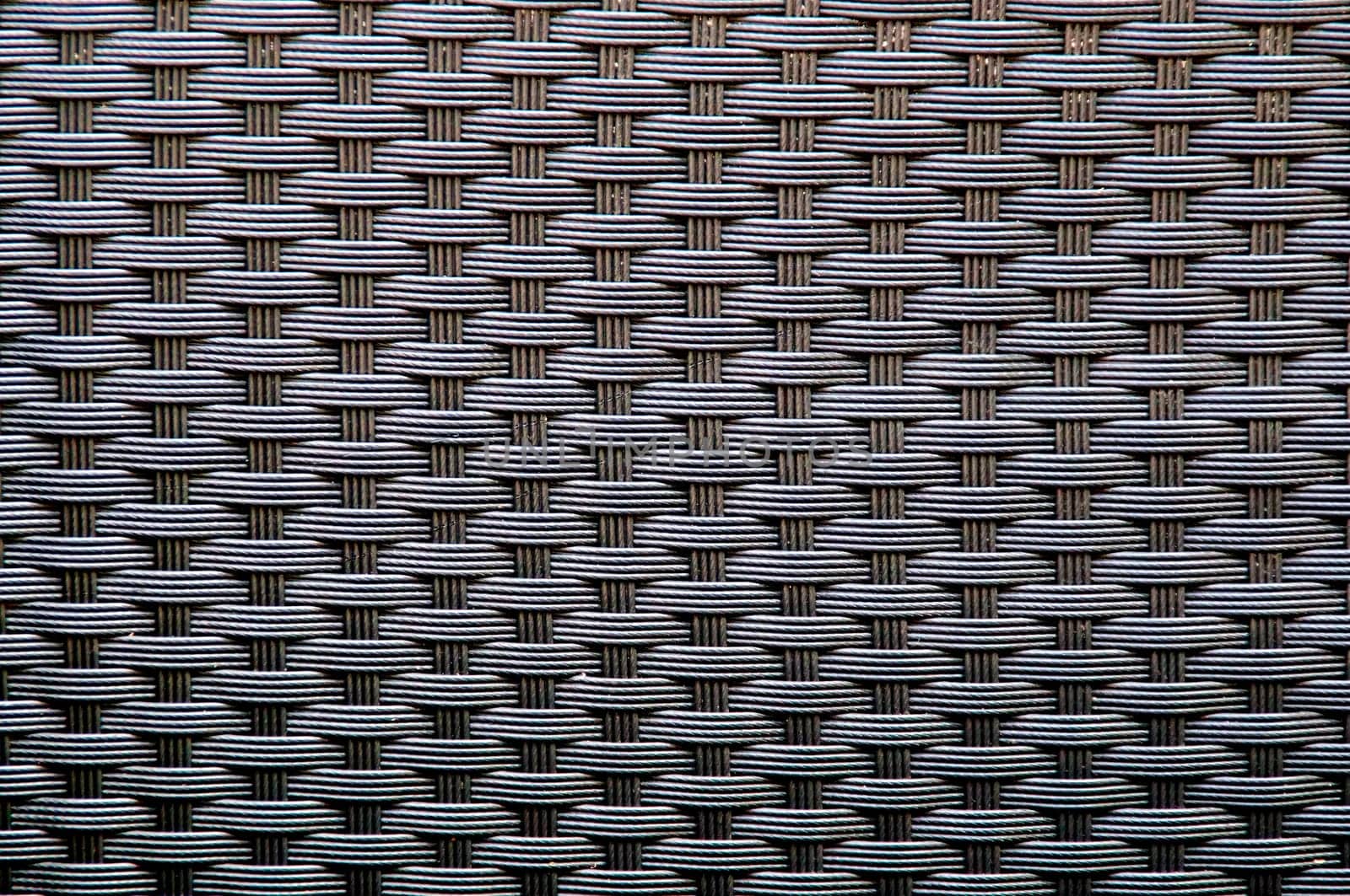 Full frame image of colored woven wicker creating optical illusion.