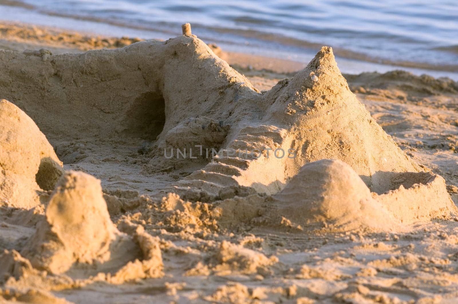 Sandcastle on the beach. Vacation concept and kids staff
