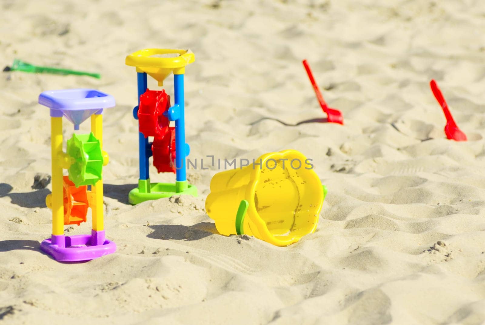 Children`s toys for sand and sunblock lotion at the beach. Summer vacations concept