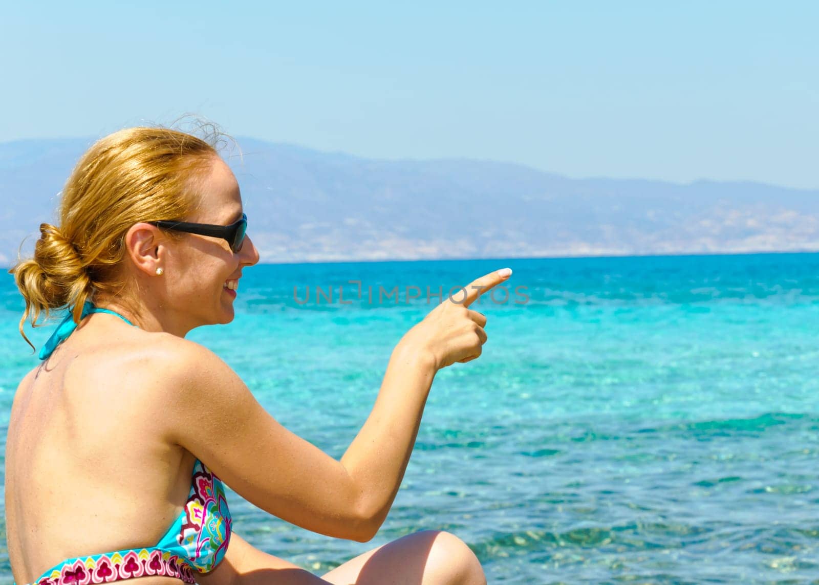Beautiful young woman in swimsuit, relaxing on a tropical sunny beach