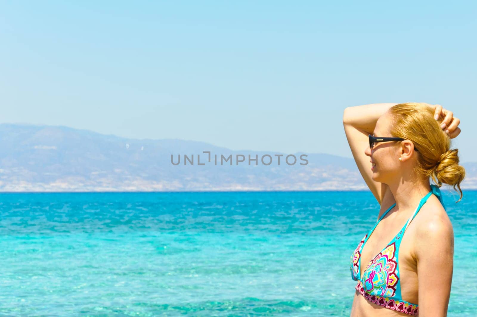 Beautiful young woman in swimsuit, relaxing on a tropical sunny beach