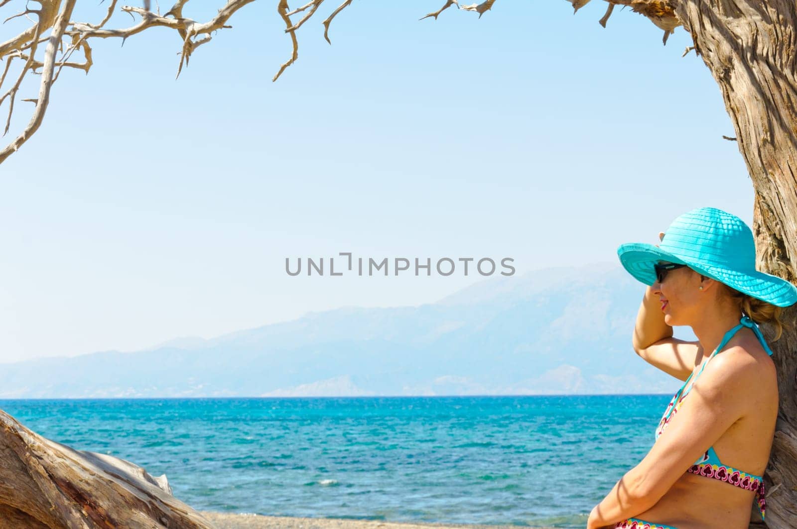 Beautiful young woman in swimsuit, relaxing on a tropical sunny beach