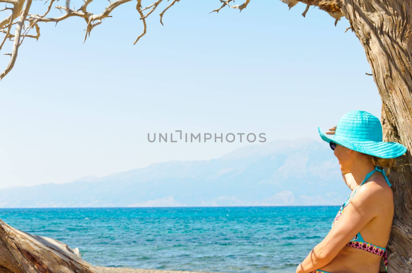Beautiful young woman in swimsuit, relaxing on a tropical sunny  beach