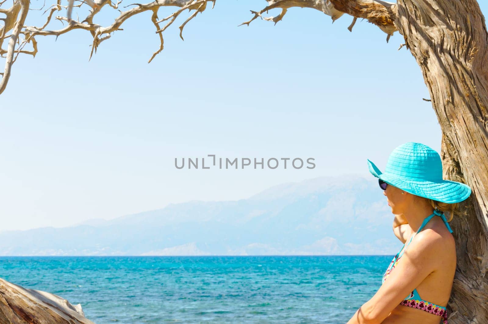 Beautiful young woman in swimsuit, relaxing on a tropical sunny  beach
