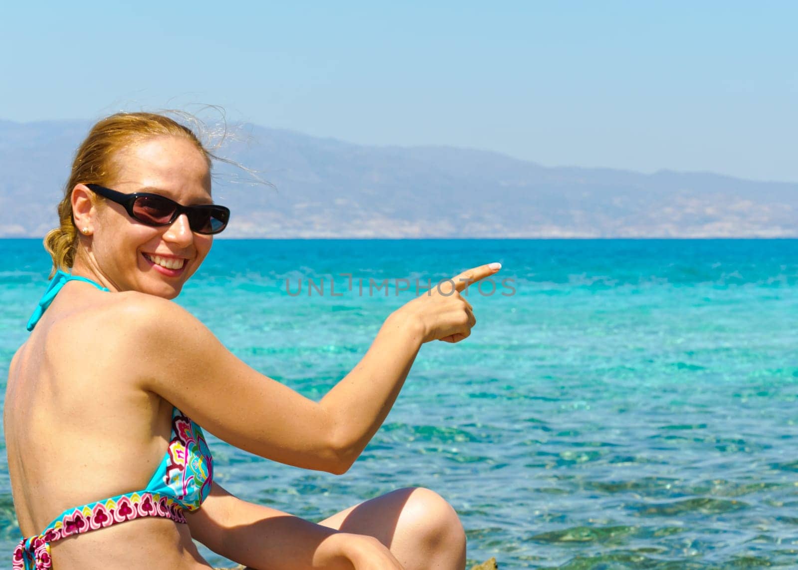 Beautiful young woman in swimsuit, relaxing on a tropical sunny beach