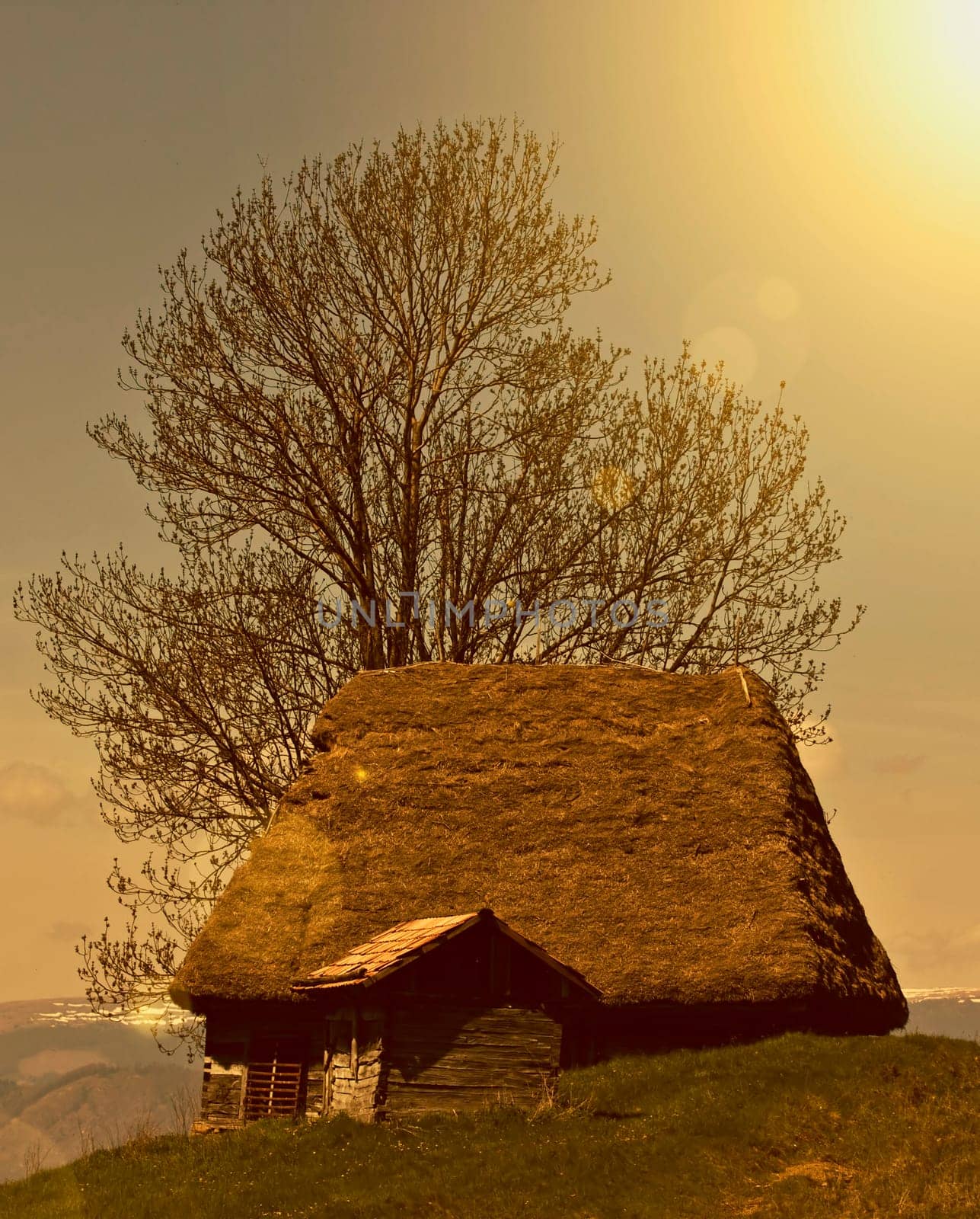 Old house in the mountains in the sunset
