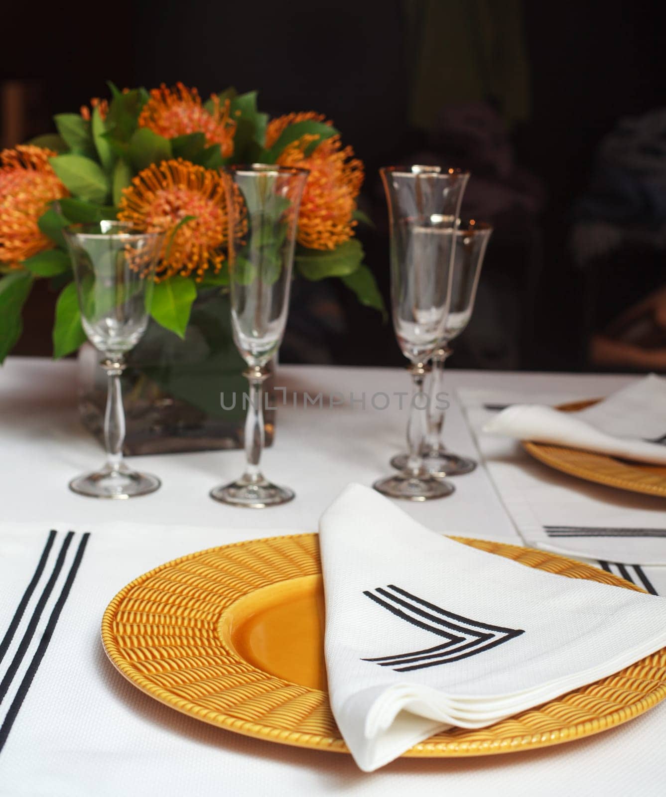View of elegant table set with orange flowers
