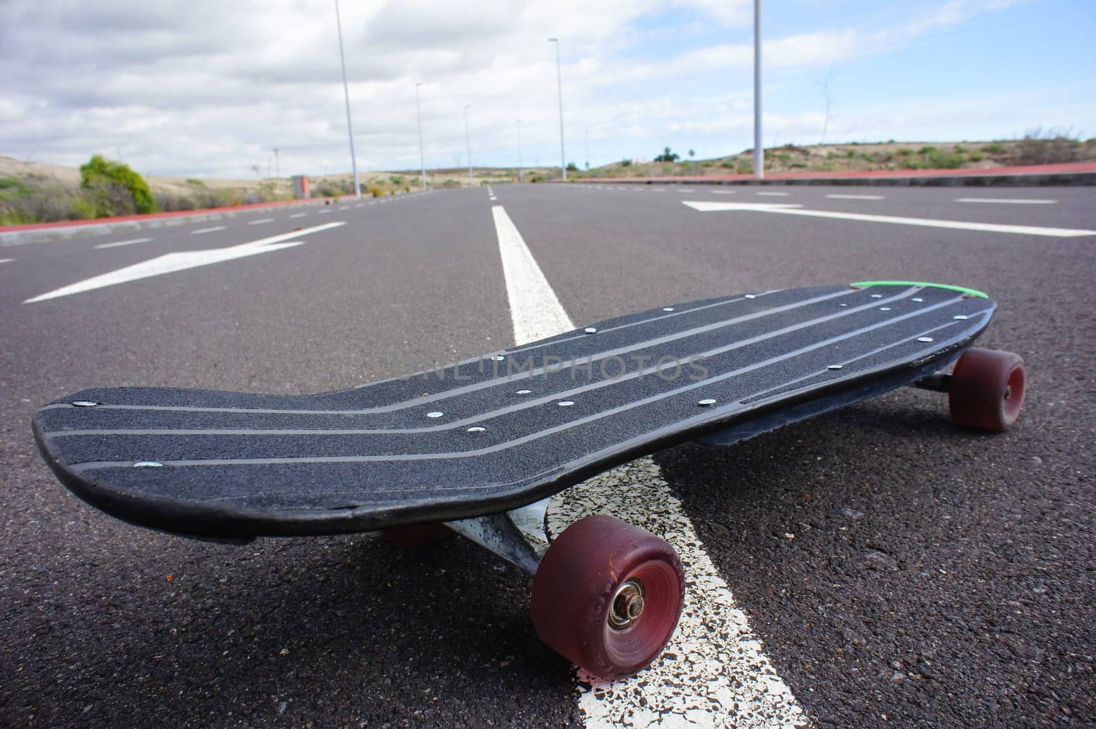 Vintage Style Longboard Black Skateboard on an Empty Asphalt Desert Road