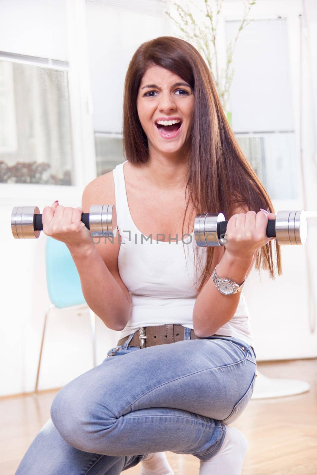 cute fit girl with dumbbells training hard at home