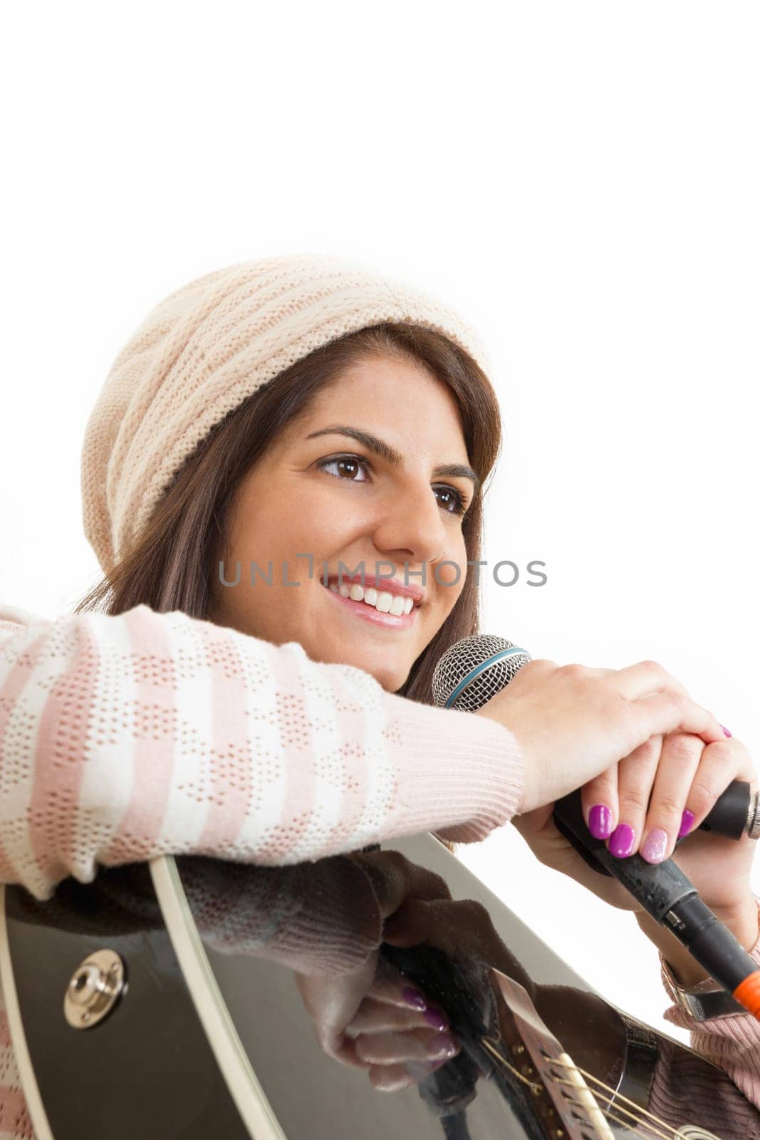 girl with cap dressed in sweater holding guitar and microphone