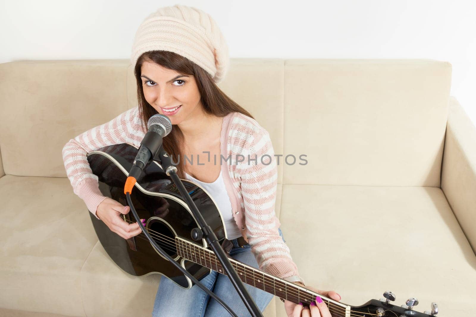 girl with a guitar and microphone wearing cap