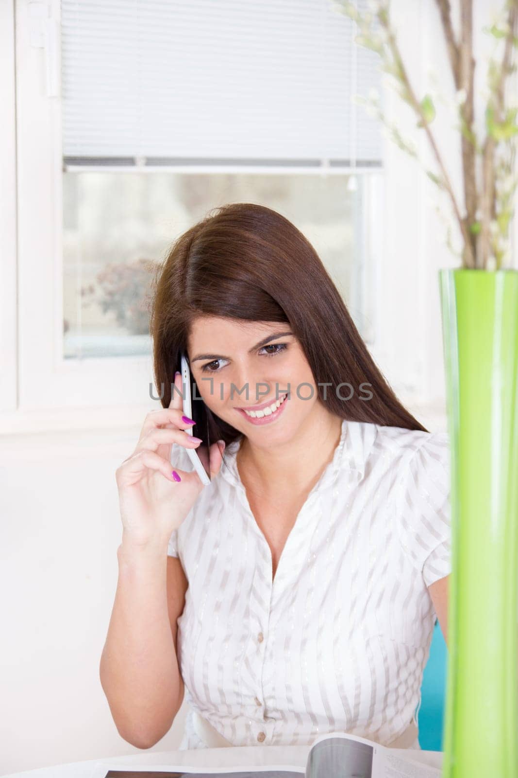 pretty girl in white shirt on the phone at home