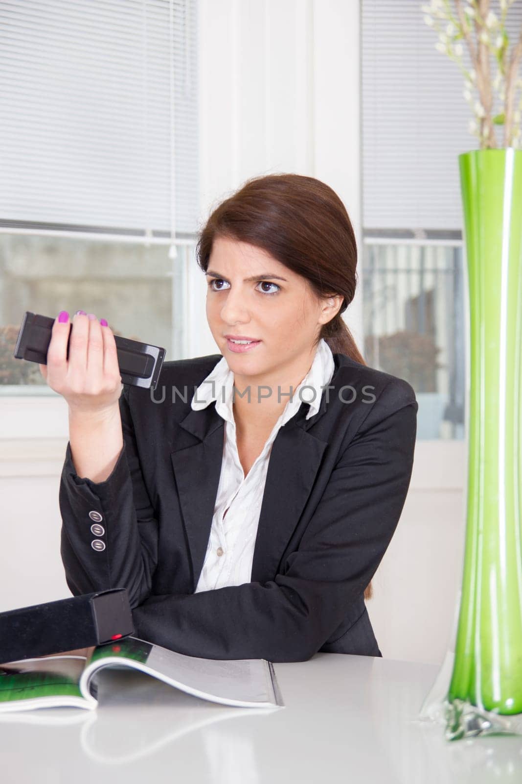 pretty business woman in suit with remote