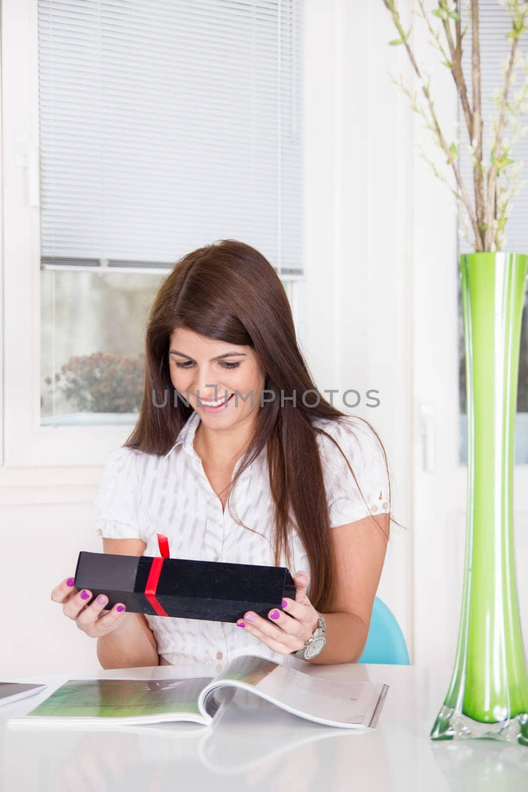 pretty smiling girl opens the gift at home