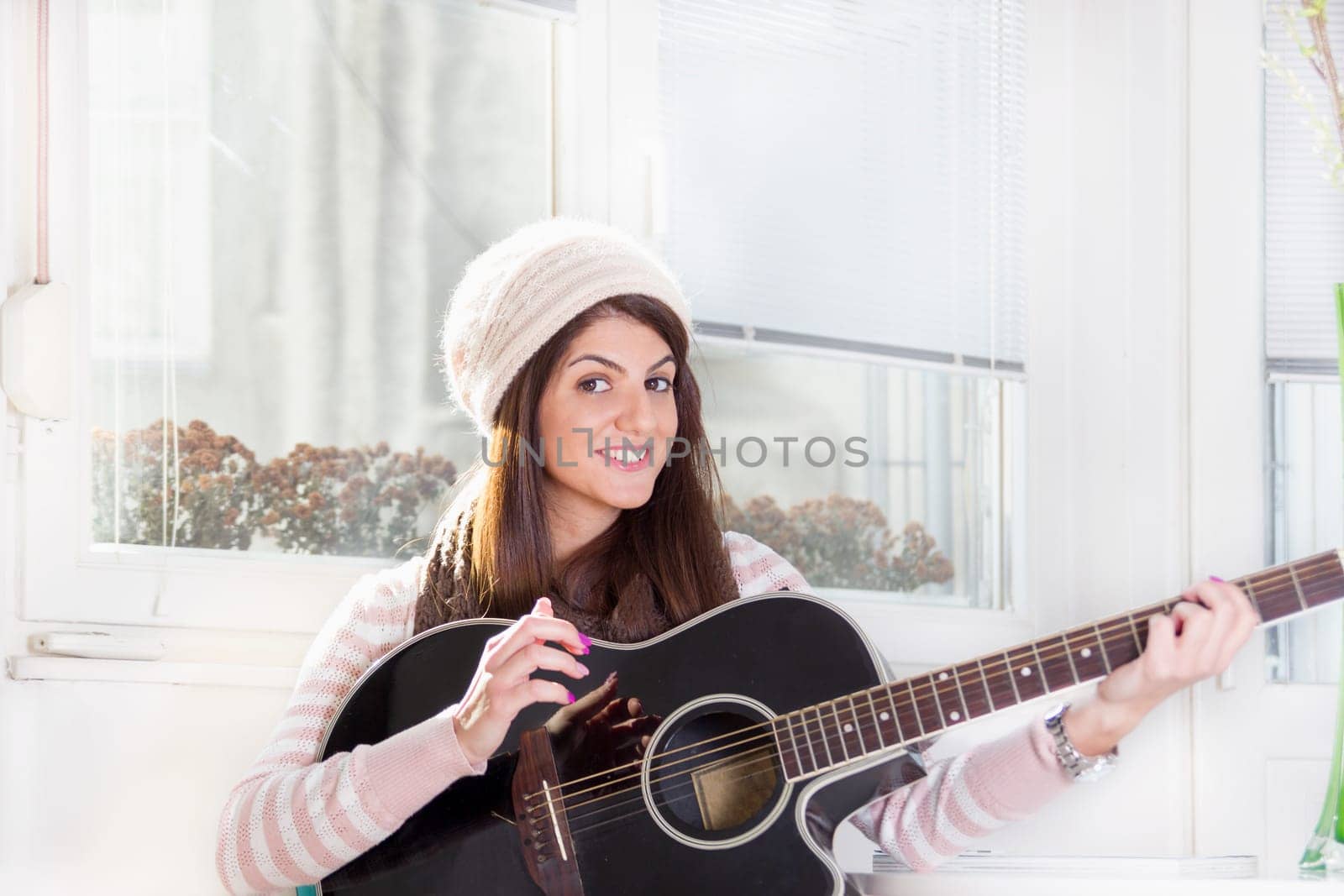 pretty girl playing the guitar and smiling