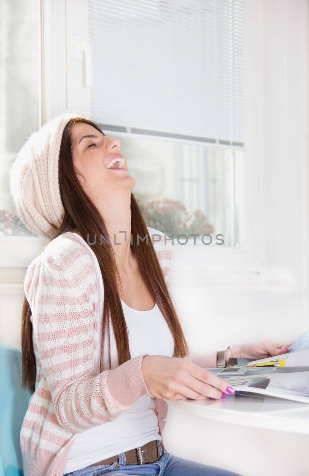 girl smiling and reading a magazine on table