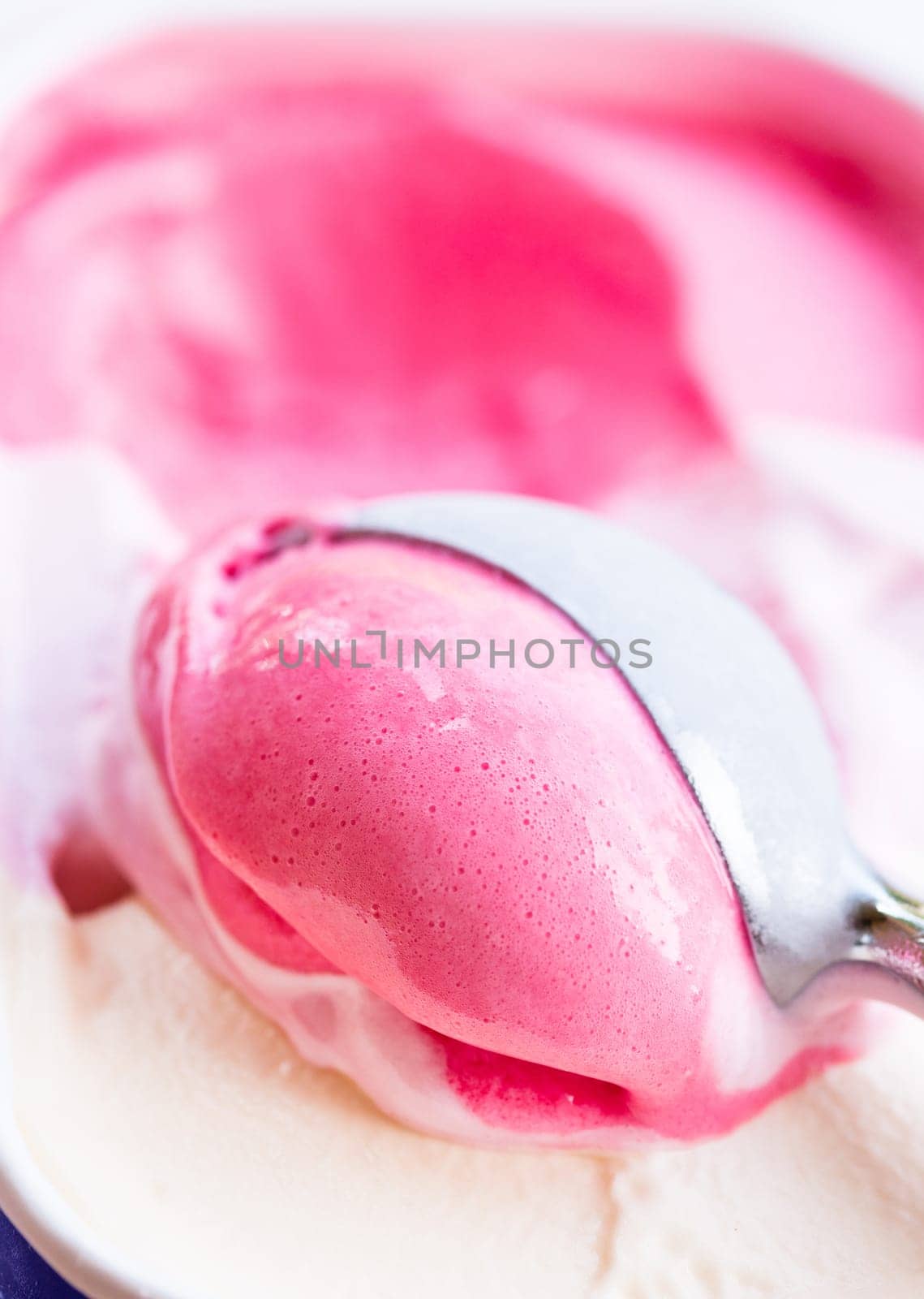Closeup of raspberry ice cream and metal ice cream scoop