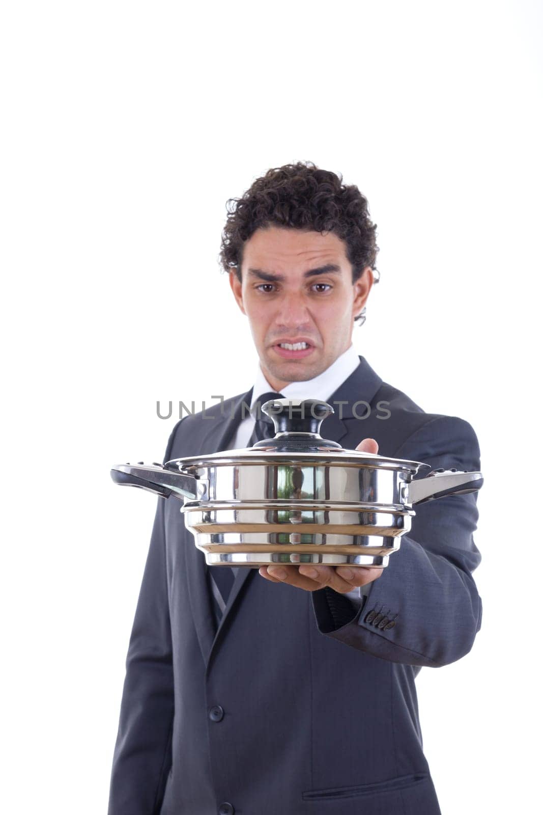 man in suit looking at pot for cooking with expression