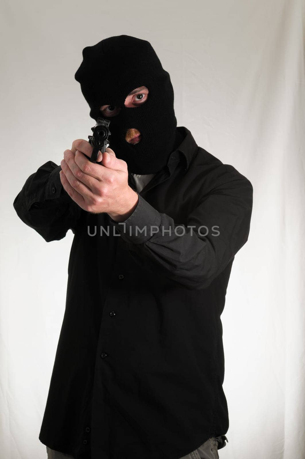 Black Dressed Young Man Holding a Pistol Gun