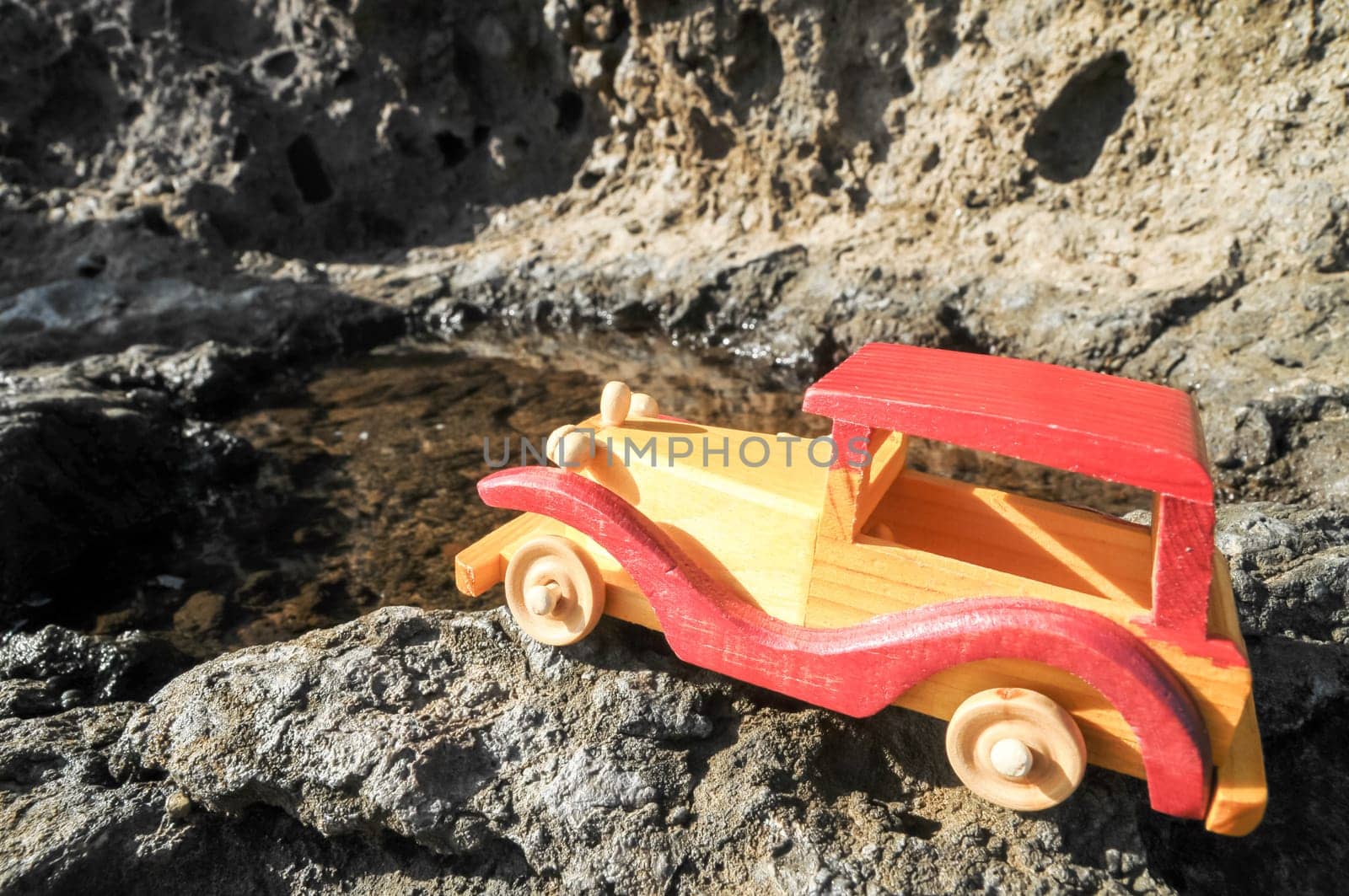 Transportation Concept Wooden Toy Car on the Rocks