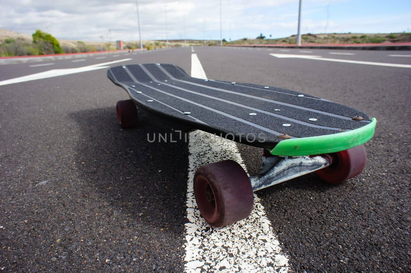 Vintage Style Longboard Black Skateboard on an Empty Asphalt Desert Road