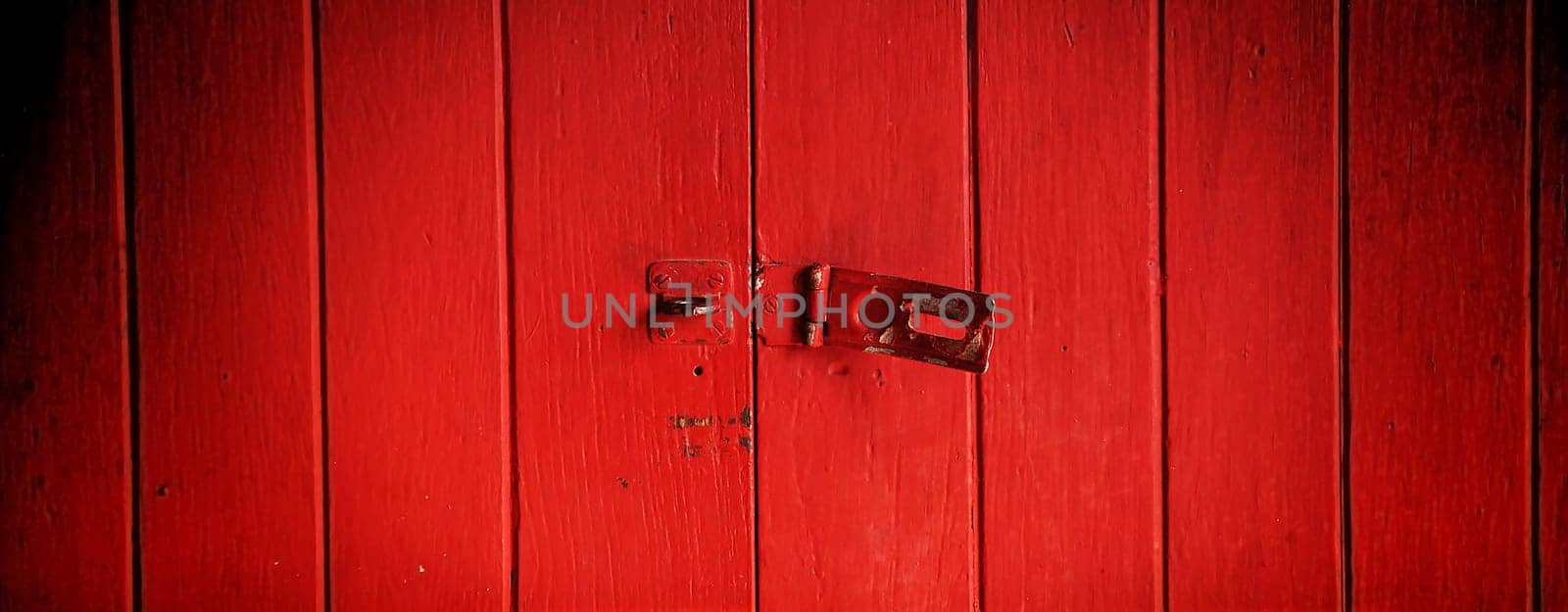 Old padlock on a red wooden door