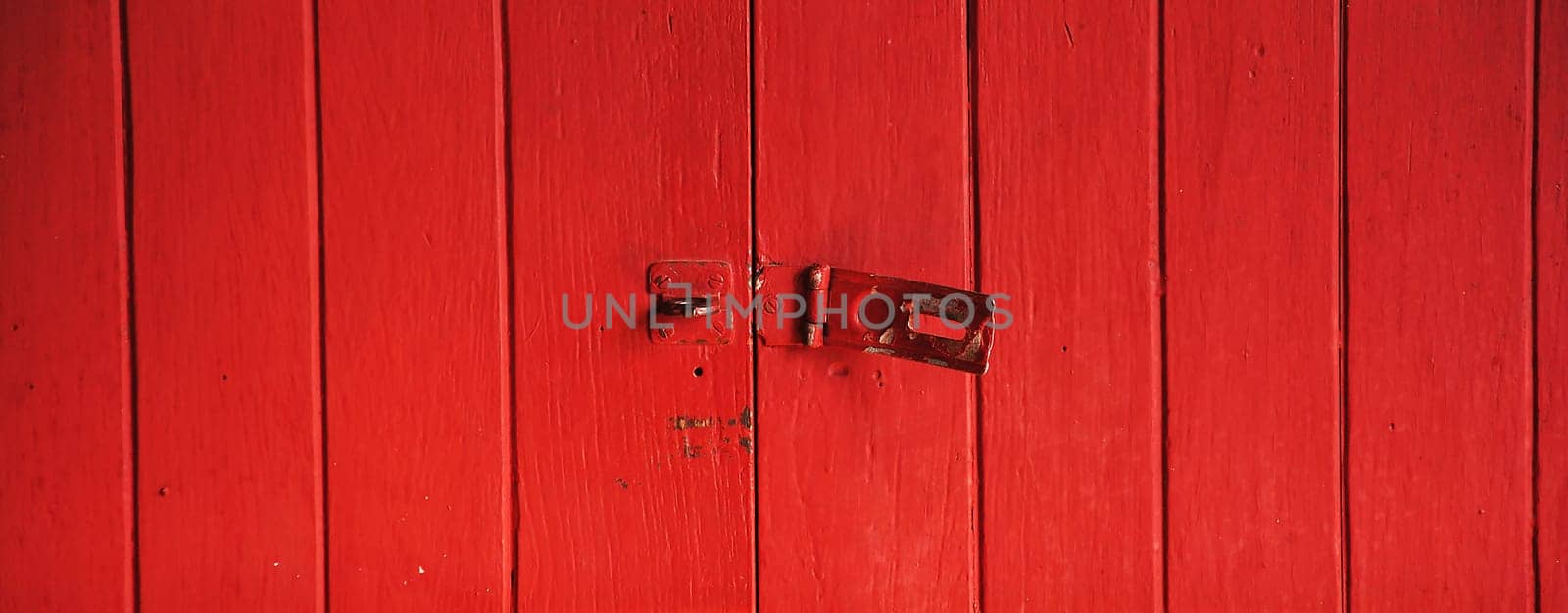 Old padlock on a red wooden door